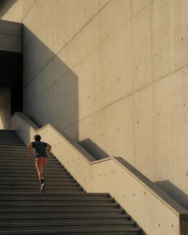 Runner climbing a long architectural staircase